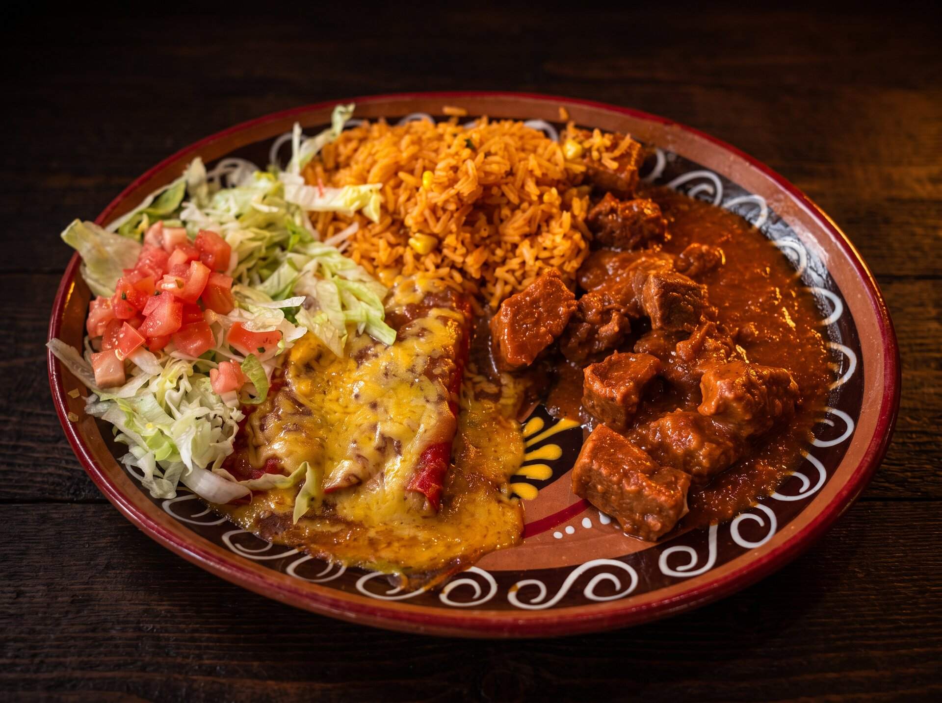 Carne guisada combination plate with rice, an enchilada, lettuce and pico de gallo