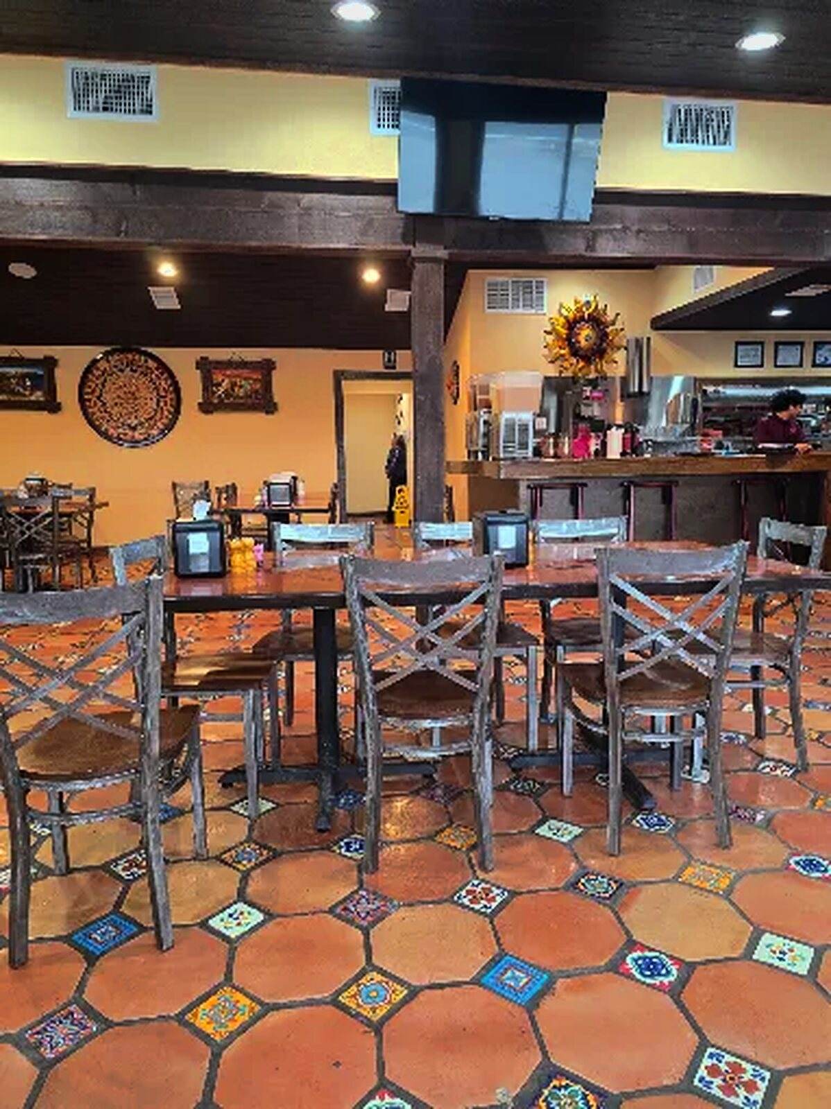 The dining room at El Jalisco #3 — wooden chairs on a patterned Talavera tile floor