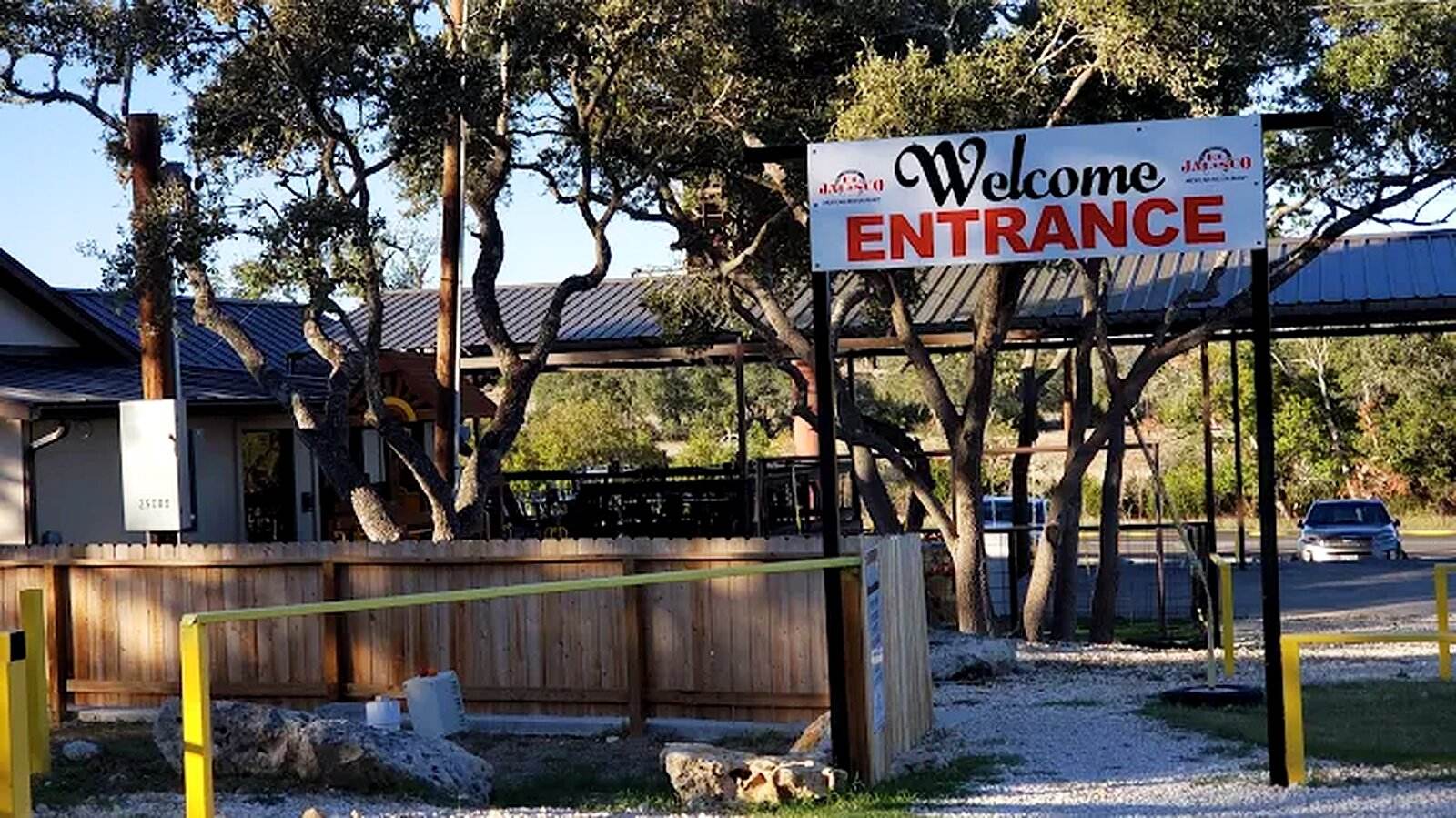 The Welcome and Entrance sign at the driveway, under the live oaks