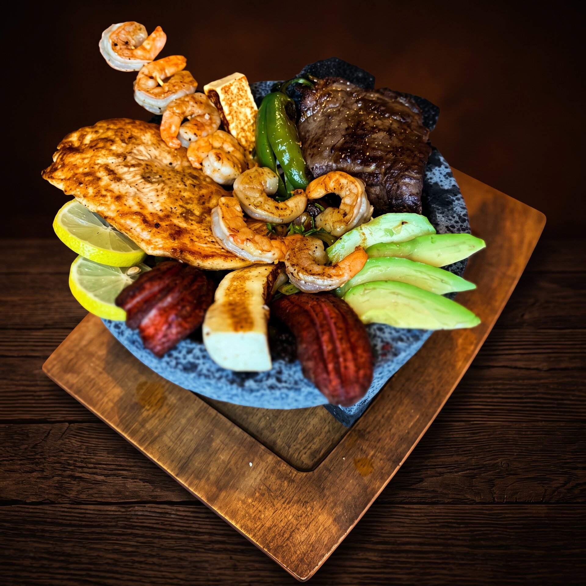 Molcajete Jalisco piled with grilled steak, chicken, shrimp, sausage and ranchero cheese