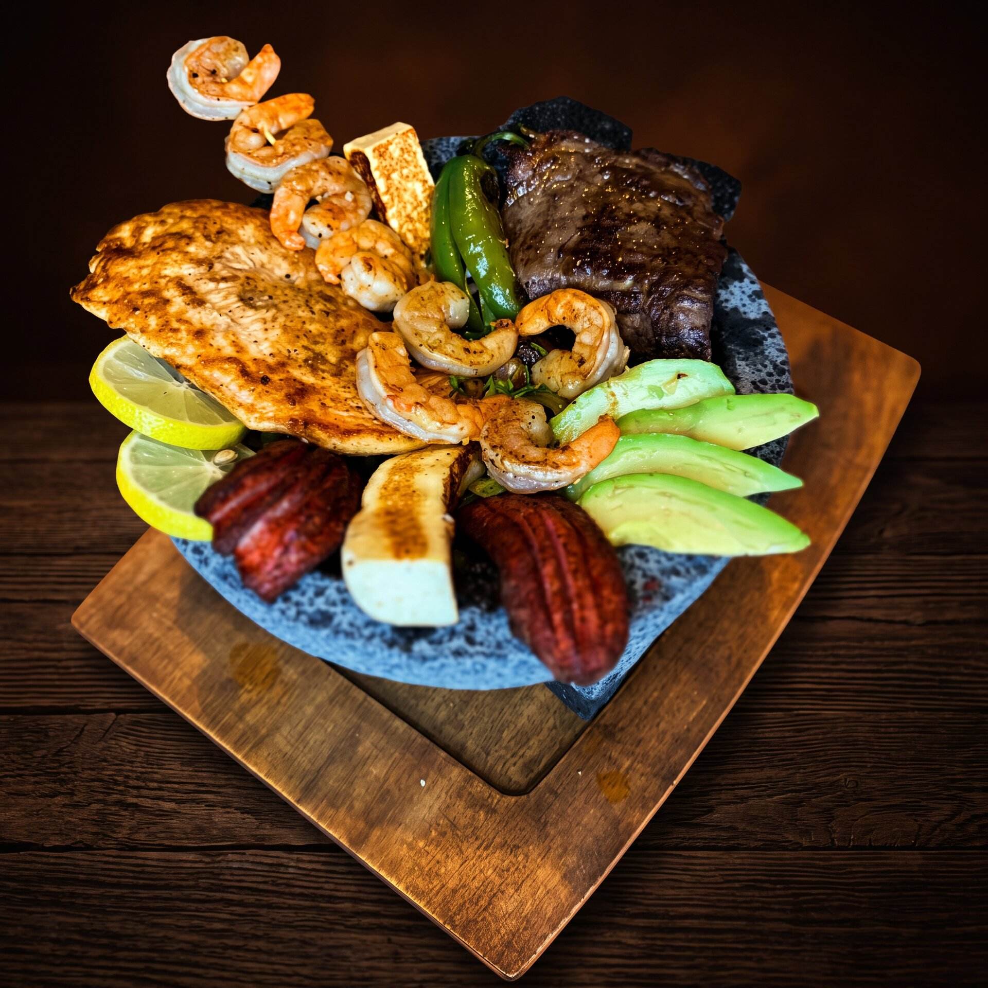 Molcajete Jalisco piled with grilled steak, chicken, shrimp, sausage and ranchero cheese