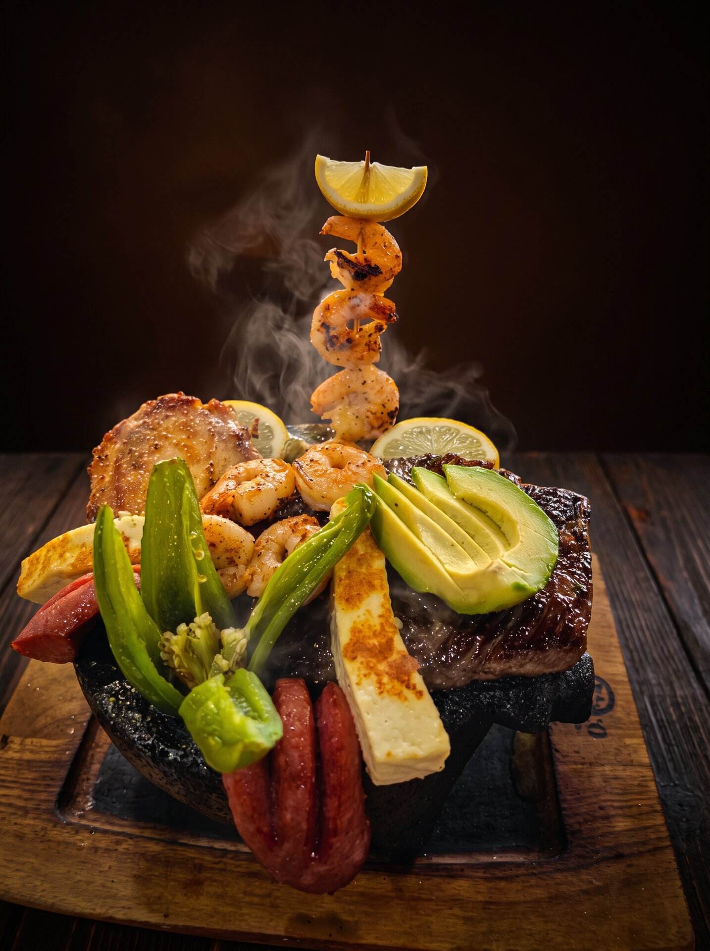 A mixed parrillada still steaming on a hot stone with a shrimp skewer standing upright